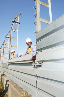 防雪柵の設置作業を進める作業員＝1日午後1時半ごろ、酒田市吉田新田