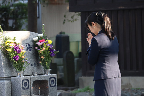 墓前で手を合わせ、父・紘一氏に大臣就任を報告する加藤大臣＝3日午前8時半ごろ、鶴岡市・正覚寺