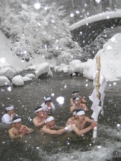 雪が降り積もる中、祓川に入る荒行に挑む出羽三山神社神職養成所の卒業生ら