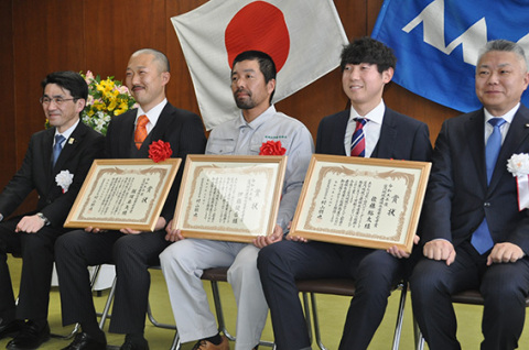 表彰状を手にする飯塚さん（左から2人目）、伊藤さん（中央）、佐藤さん