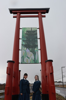 モニュメントの前に立つ土門さんと鈴木さん（右）。東側には鈴木さんの五重塔とミズバショウの作品が飾られた
