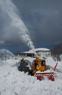 除雪車のごう音が鳥海山に響く。奥は大平山荘