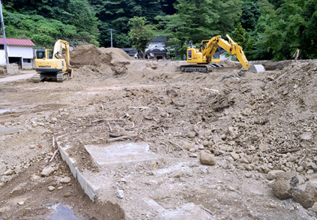 酒田市北青沢の小屋渕集落では堆積した土砂の撤去作業が進む＝25日午後