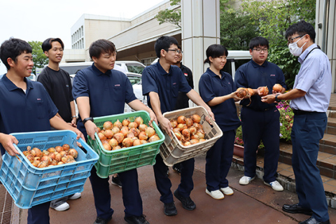 鶴岡市学校給食センターに栽培したタマネギを届けた庄内農業高の生徒たち