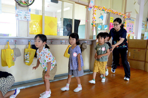 保育士に誘導され避難する園児たち