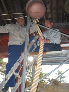 真新しい鈴緒を取り付ける神社関係者