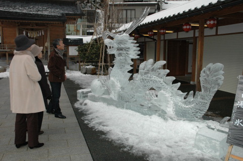 地元の調理師らが制作した氷の彫刻「龍」に見入る観光客ら