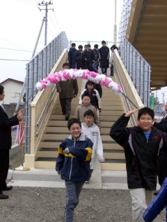 児童たちが渡り初めをし新歩道橋の完成を祝った