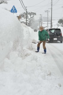 大雪に見舞われ、住民が除雪作業に追われた。道路脇には高い雪の壁が出現＝4日午前10時ごろ、鶴岡市宝町