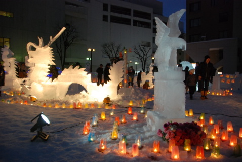 氷の彫刻とキャンドルが幻想的な世界を演出し、大勢の見物客が訪れた「雪氷まつり」＝旧ジャスコ鶴岡店跡地広場