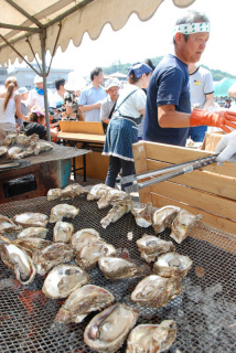 人気の焼きガキを販売するテントの前に、家族連れなどが行列をつくった