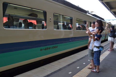 列車の窓越しに手を振り、別れを惜しむ人たち＝15日午前10時5分ごろ、ＪＲ鶴岡駅