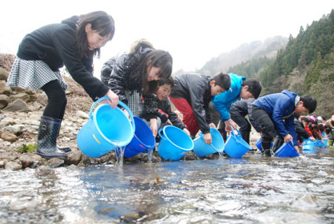 大きくなって戻ってきてね―。サケの稚魚を見送る子どもたち